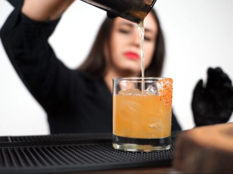 Professional mixologist behind illuminated LED bar